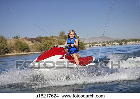 Picture - Young woman riding jetski on lake, portrait. Fotosearch