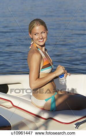 Stock Photo - Young woman sitting in boat. Fotosearch