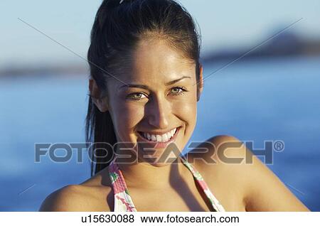 Stock Photo - Young woman smiling, outdoors, portrait. Fotosearch