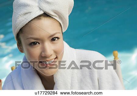Picture - Young woman wearing bathrobe by swimming pool, portrait. Fotosearch