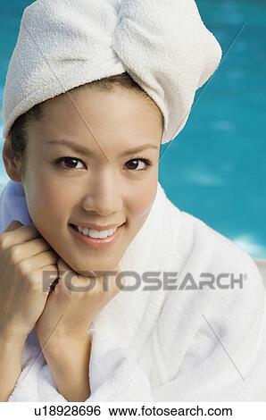 Young woman wearing bathrobe by swimming pool, portrait View Large Photo Image Stock Photograph - Young woman wearing bathrobe by swimming pool, portrait. Fotosearch