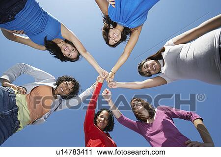 Young women standing in circle, view from below View Large Photo Image Stock Image - Young women standing in circle, view from below. Fotosearch