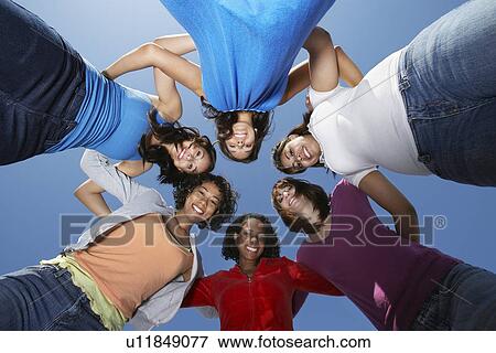 Young women standing in circle, view from below View Large Photo Image Stock Photo - Young women standing in circle, view from below. Fotosearch