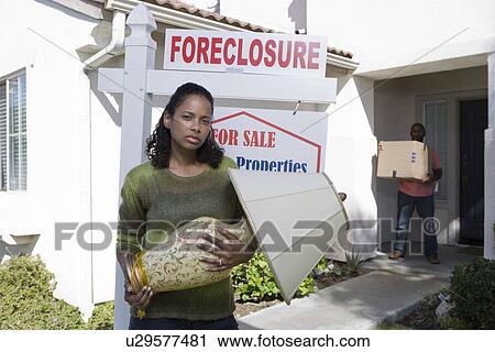 Stock Image - Bankrupt couple moving out of house. Fotosearch