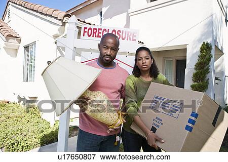 Stock Photo - Bankrupt couple moving out of house. Fotosearch