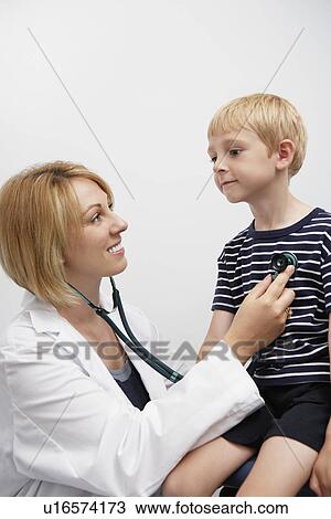 Stock Image - Boy being examined by female doctor. Fotosearch