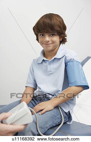 Stock Image - Boy having blood presure taken. Fotosearch