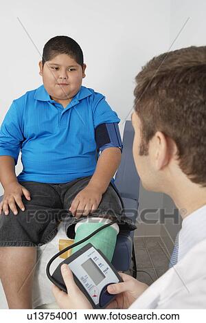 Boy having his blood pressure checked by doctor View Large Photo Image Stock Image - Boy having his blood pressure checked by doctor. Fotosearch