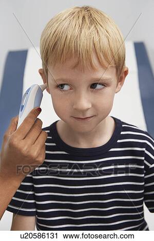Boy having temperature taken with ear thermometer View Large Photo Image Stock Image - Boy having temperature taken with ear thermometer. Fotosearch