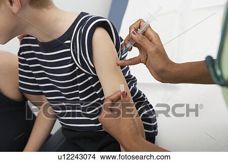 Boy receiving injection, close up view View Large Photo Image Picture - Boy receiving injection, close up view. Fotosearch