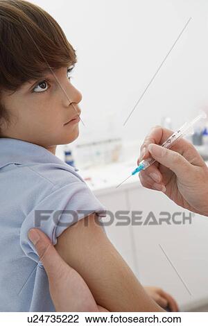 Stock Image - Boy receiving injection. Fotosearch