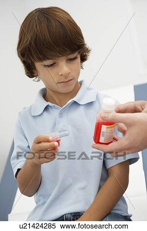 Stock Photography - Boy taking medicine. Fotosearch