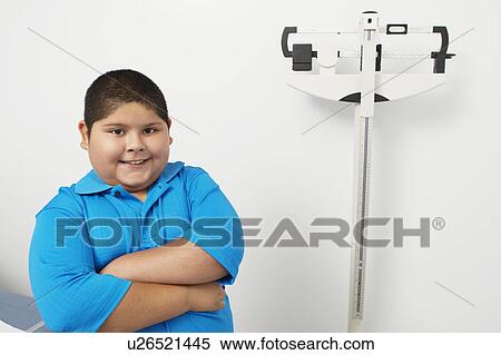 Stock Photography - Boy with arms crossed in hospital, portrait. Fotosearch
