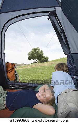 Stock Photo - Brother and sister lie in a tent. Fotosearch