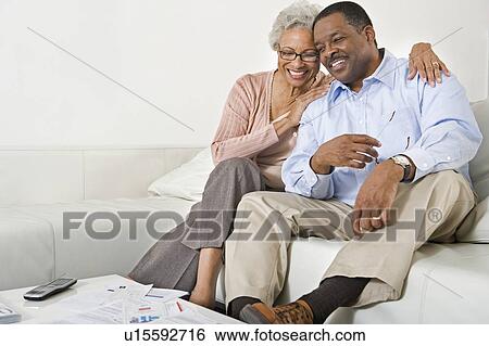 Stock Photograph - Cheerful Senior Couple On Couch. Fotosearch