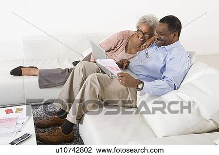 Stock Image - Cheerful Senior Couple Using Laptop. Fotosearch