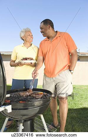Couple at a barbeque View Large Photo Image Stock Photograph - Couple at a barbeque. Fotosearch
