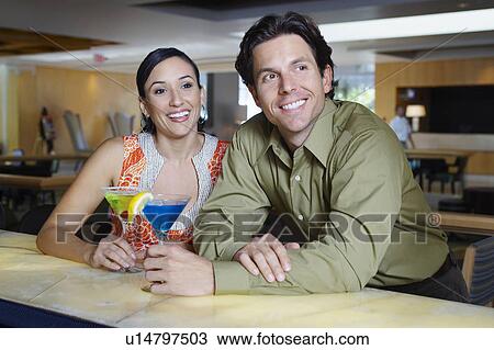 Stock Image - Couple Drinking Martinis at a Bar. Fotosearch