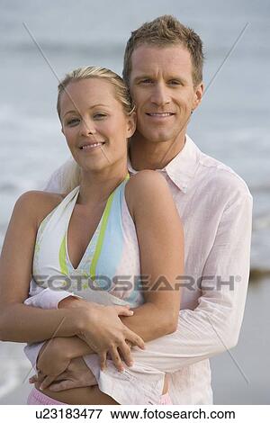 Stock Photo - Couple embracing at the beach. Fotosearch