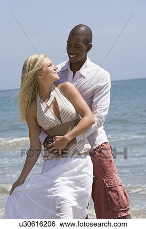 Couple embracing on beach View Large Photo Image Stock Photograph - Couple embracing on beach. Fotosearch