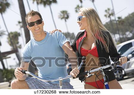 Couple on bikes at the beach View Large Photo Image Stock Photo - Couple on bikes at the beach. Fotosearch
