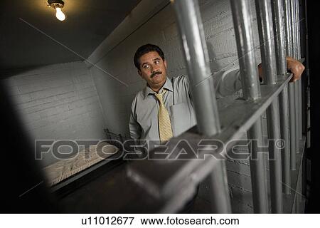 Criminal behind bars in jail View Large Photo Image Stock Photo - Criminal behind bars in jail. Fotosearch