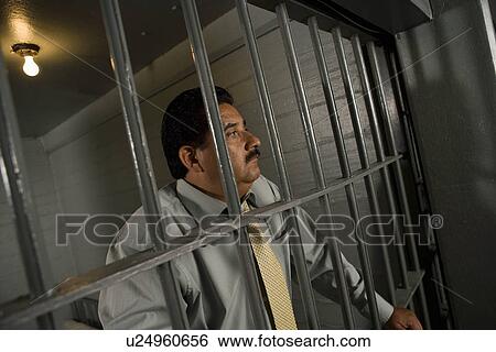 Criminal behind bars in jail View Large Photo Image Stock Photograph - Criminal behind bars in jail. Fotosearch