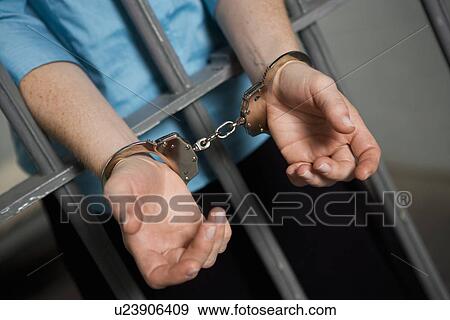 Criminal handcuffed to bars in jail View Large Photo Image Stock Photo - Criminal handcuffed to bars in jail. Fotosearch