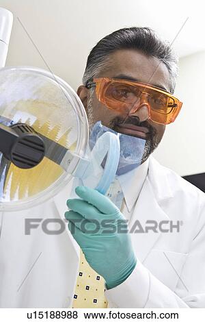 Stock Photo - Dentist adjusting lamp. Fotosearch