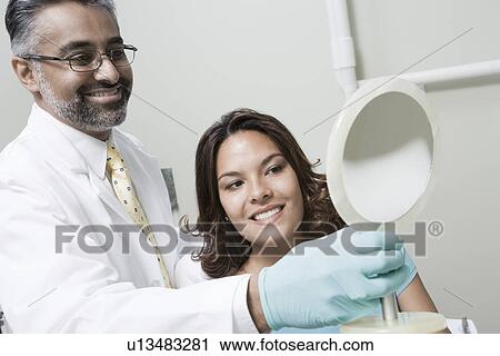 Dentist and patient using mirror View Large Photo Image Stock Image - Dentist and patient using mirror. Fotosearch