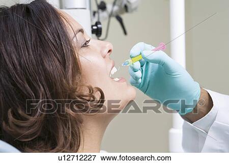 Stock Photo - Dentist inspecting patient's teeth. Fotosearch