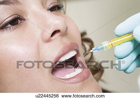 Stock Photograph - Dentist inspecting patient's teeth. Fotosearch