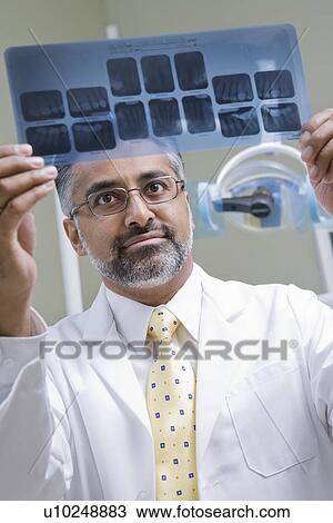 Dentist looking at x-ray View Large Photo Image Stock Image - Dentist looking at x-ray. Fotosearch