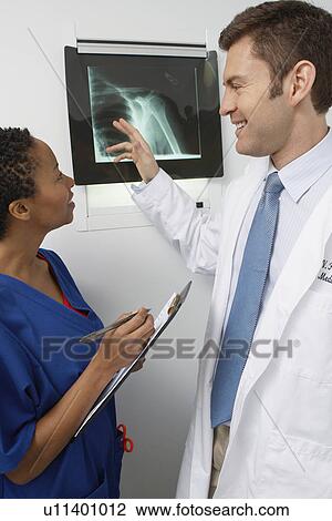 Doctor and nurse examining x-ray in hospital View Large Photo Image Stock Image - Doctor and nurse examining x-ray in hospital. Fotosearch