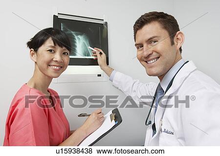 Doctor and nurse examining x-ray in hospital, portrait View Large Photo Image Stock Photo - Doctor and nurse examining x-ray in hospital, portrait. Fotosearch