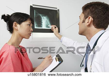 Doctor and nurse examining x-ray in hospital View Large Photo Image Stock Photograph - Doctor and nurse examining x-ray in hospital. Fotosearch