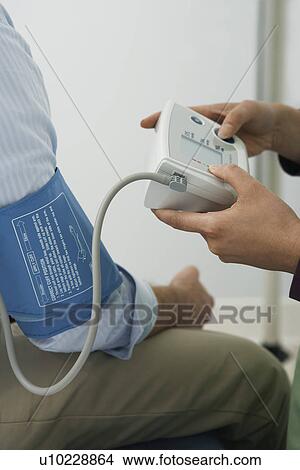 Doctor checking patients blood pressure, close-up View Large Photo Image Picture - Doctor checking patients blood pressure, close-up. Fotosearch