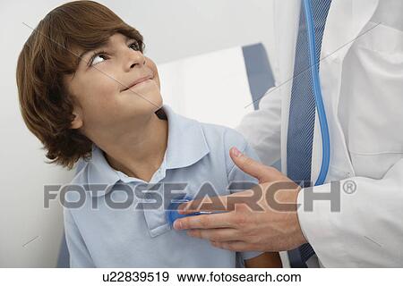 Doctor examining boy View Large Photo Image Stock Photo - Doctor examining boy. Fotosearch