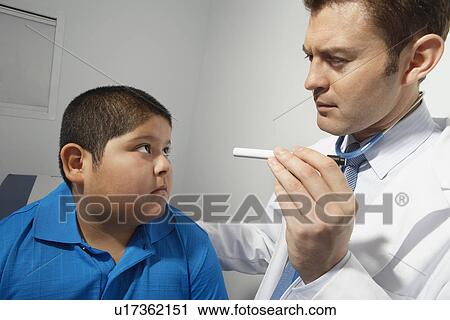 Doctor examining boy's eye balls View Large Photo Image Stock Image - Doctor examining boy's eye balls. Fotosearch