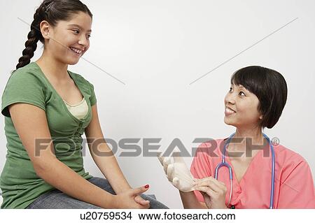 Doctor examining girl in hospital View Large Photo Image Picture - Doctor examining girl in hospital. Fotosearch
