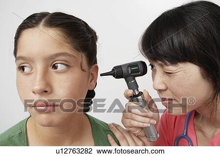 Stock Image - Doctor examining girl in hospital. Fotosearch