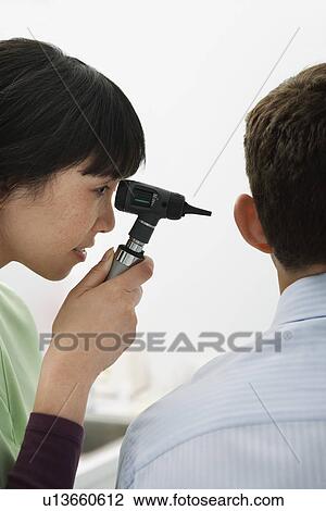 Stock Image - Doctor examining male patient in hospital. Fotosearch