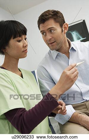 Stock Image - Doctor examining male patient in hospital. Fotosearch