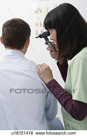 Doctor examining male patient in hospital View Large Photo Image Stock Photo - Doctor examining male patient in hospital. Fotosearch