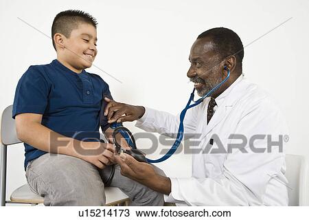 Doctor examining pre-teen (10-12) boy View Large Photo Image Stock Image - Doctor examining pre-teen (10-12) boy. Fotosearch