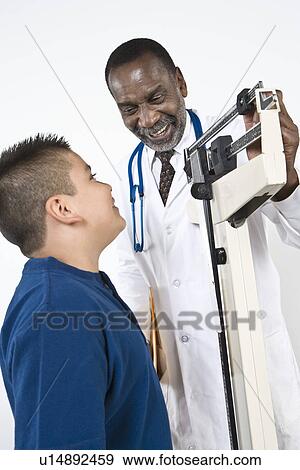 Stock Photo - Doctor examining pre-teen (10-12) boy. Fotosearch
