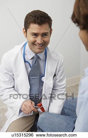 Doctor examining young patient with reflex hammer View Large Photo Image Stock Photograph - Doctor examining young patient with reflex hammer. Fotosearch