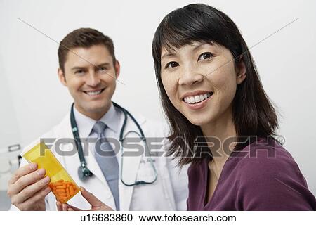 Doctor giving female patient medication in hospital View Large Photo Image Stock Image - Doctor giving female patient medication in hospital. Fotosearch