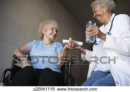 Stock Photo - Doctor helping disabled patient. Fotosearch
