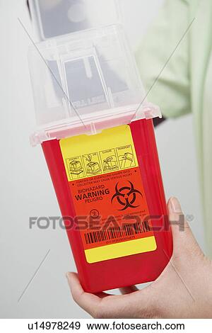 Stock Photo - Doctor holding medical container in hospital, close-up. Fotosearch